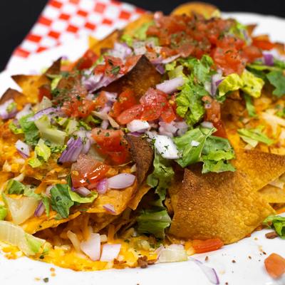Nachos with cheese, lettuce, onions, and tomatoes..