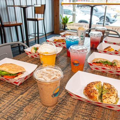 Assorted sandwiches and drinks on wooden table.