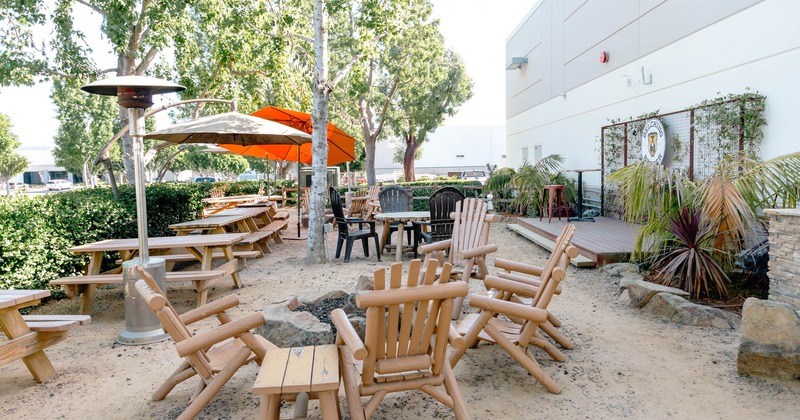 Exterior, seating area, outdoor heaters, parasols, a hedge, outdoor stage