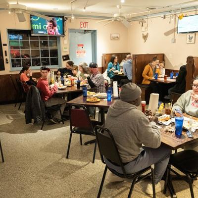 Dining room interior with guests seated in booths and at tables.
