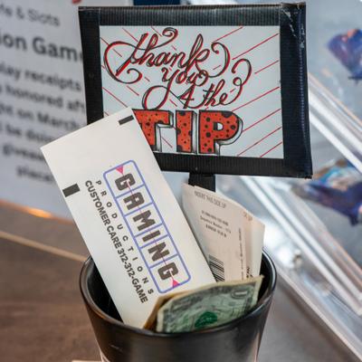 Cash vouchers and one-dollar bills in a tip jar.
