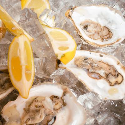 Raw oysters served on ice with fresh lemon wedges.