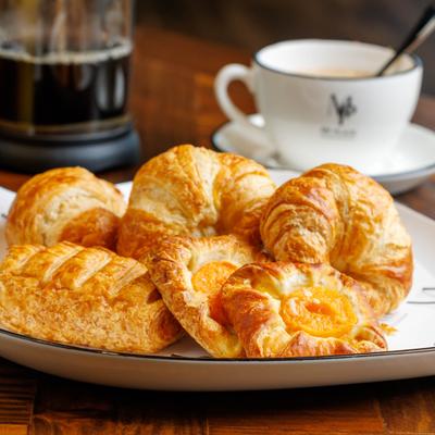 Assorted croissants served with coffee on a wooden table.