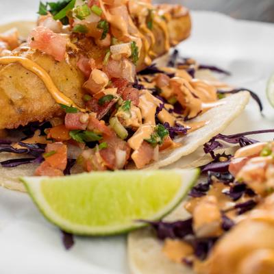 Baja fish taco with cabbage and lime wedge.