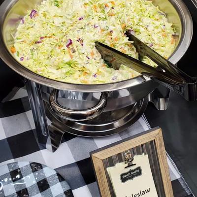 A silver chafing dish filled with coleslaw.
