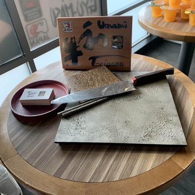 Knife and board for meat cutting placed on a table.