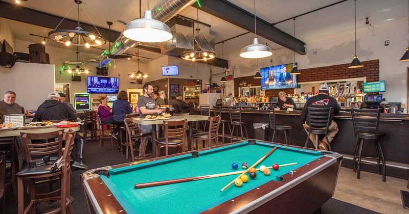 Interior space, bar and seating area with guests, pool table