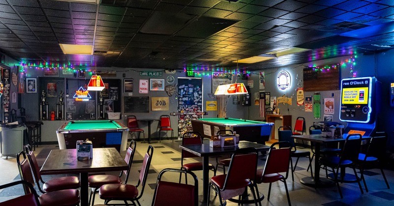 Interior, wide view of seating area, tables and chairs, pool tables in the back