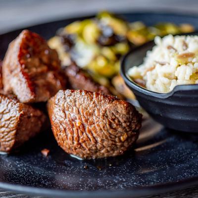 Marinated steak tips, served with rice and brussels sprouts.