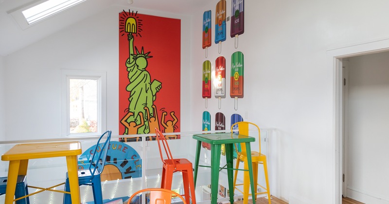Interior, different-colored tables and chairs, pop art mural decor