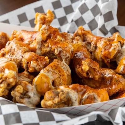 Fried chicken wings covered in spicy sauces.