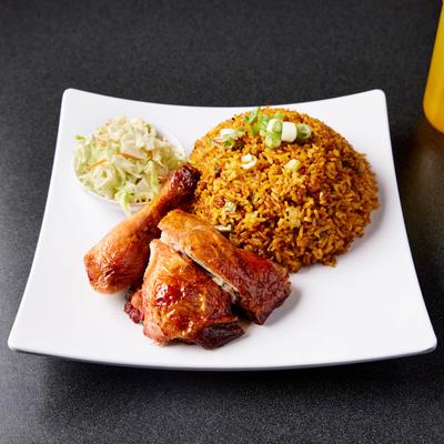 Rotisserie chicken, fried rice and Venezuelan style coleslaw on a square white plate.