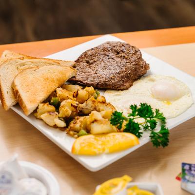 Steak and eggs with home fries and toast.