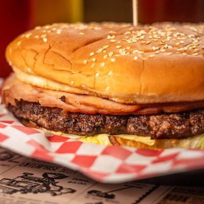 Burger served in checkered paper, close-up.
