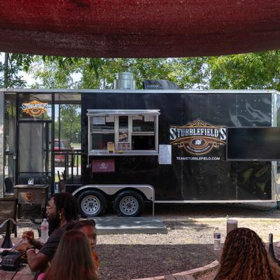 Black Stubblefield’s BBQ food truck with outdoor seating.
