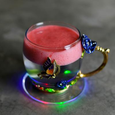 Floral glass mug with a 3D butterfly filled with a drink