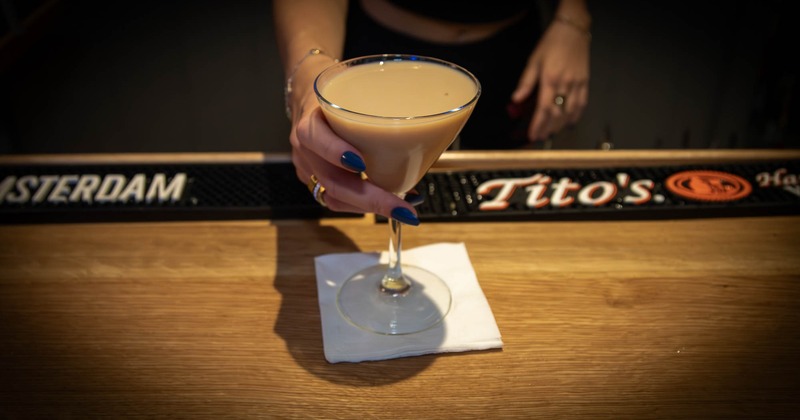 A hand serving a Dirty Martini