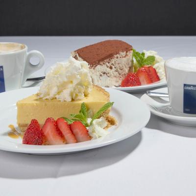 Panna Cotta served alongiside two cups of coffe and a Tiramisu.