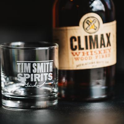 A bottle of the Climax Whiskey and an empty glass next to it.