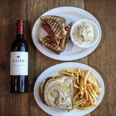 Yawkey Way and Commonwealth Avenue sandwich plates with a bottle of Hahn wine, flat lay.
