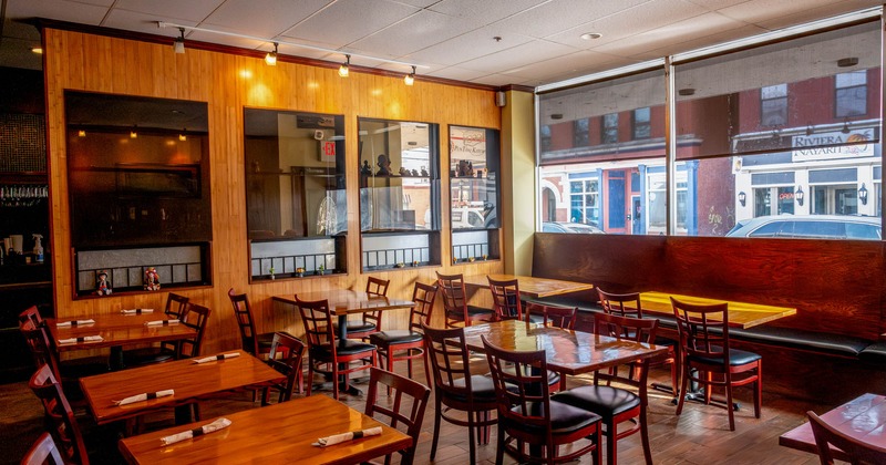Covered seating area with wooden tables and chairs