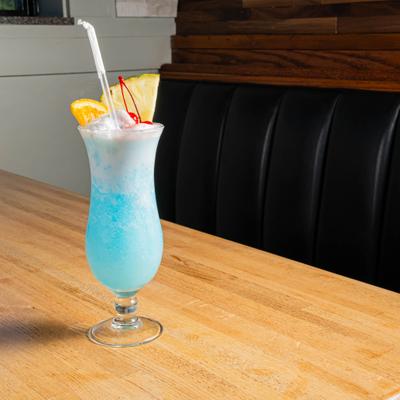 Blue Hawaiian cocktail with pineapple, cherry, and maraschino cherry garnish.