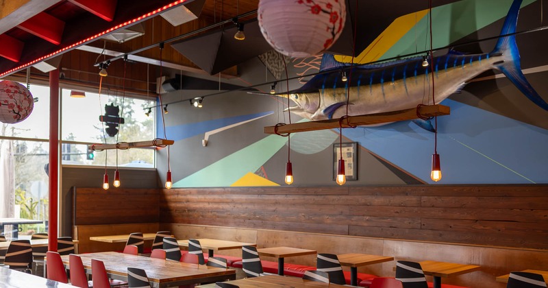 Interior, tables and chairs in seating area with swordfish on the wall