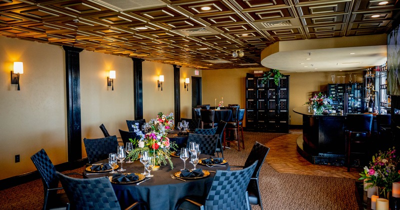 Elegant dining area - round tables, floral centerpieces and a decorative ceiling.