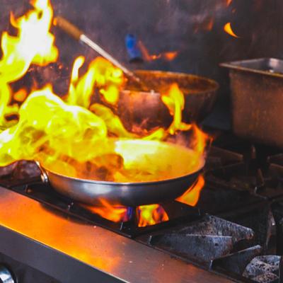 Pans cooking over open stove flames.