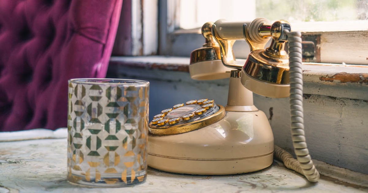 Interior decor, a vintage rotary phone and a candle holder on an ornate table