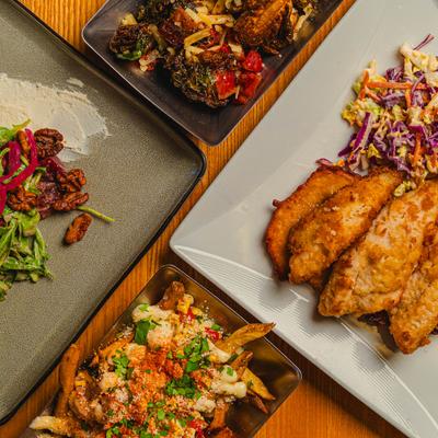MUltiple dishes on table, loaded french fries, perch fry.