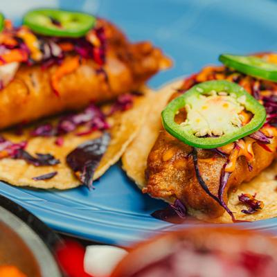 Cod tacos topped with cabbage and jalapenos.