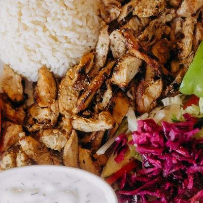 Chicken gyro platter with rice, pickled cabbage, and tzatziki sauce.