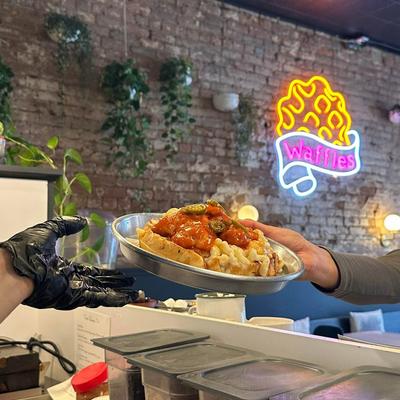 Plated waffle dish being handed over the counter.