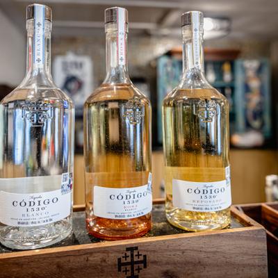 Tree different tequila bottles displayed on a wooden case.