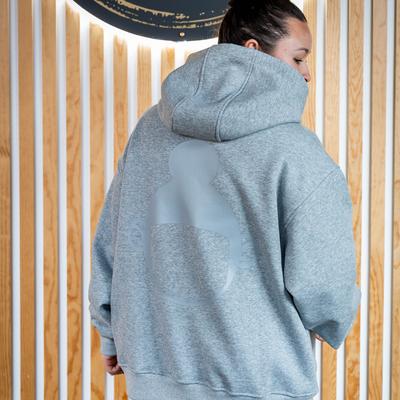 Woman in an light gray ''Hula Pot'' hoodie with logo, back view, closeup.