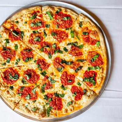 Pizza topped with fresh basil and sauce.