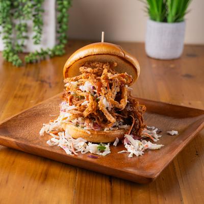 Smoked pulled pork sandwich, with bourbon BBQ sauce, coleslaw, onions, and pickles.