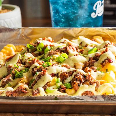 Loaded fries, with gouda cheese, scallions, cilantro crema, and brisket.