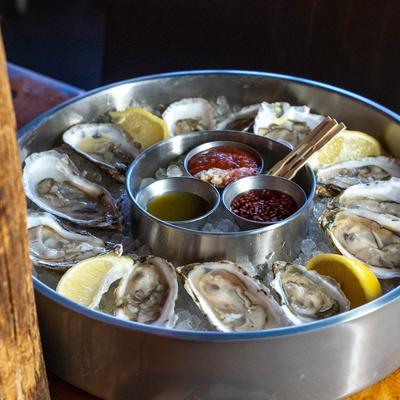 Plate of freshly shucked oysters with dipping sauces..