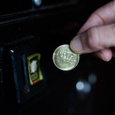 Inserting Pixels token into a machine, close up.