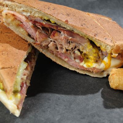 Cuban sandwich served with tater tots.