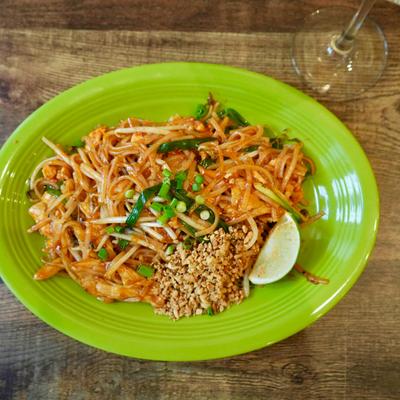 Chicken Pad Thai on a vibrant green plate.
