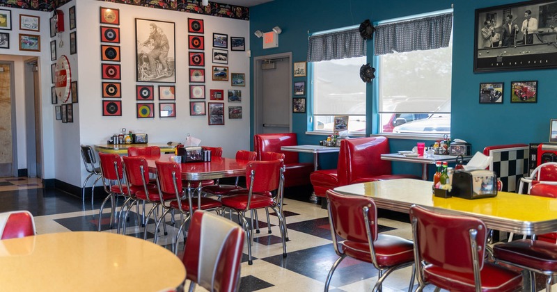 Interior, tables ready for guests, walls decorated with pictures