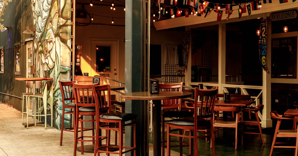An outdoor restaurant seating area with wooden tables and chairs