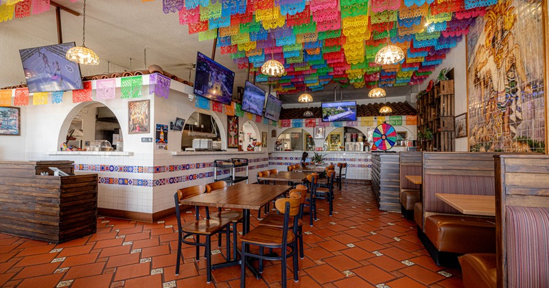Interior, wooden tables and chairs, two flat-screen TVs on the walls