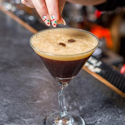 A glass of Espresso Martini on a bar counter.