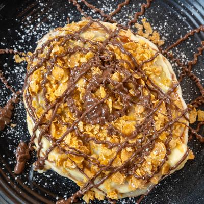 Sweet pancake topped with Nutella and corn flakes.
