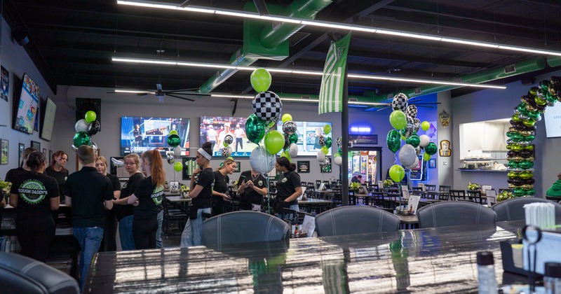 Interior, dining space with balloons and TV screens on the walls