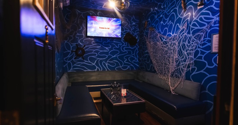 Colorful karaoke room with a disco ball and a TV